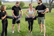 © rh2010 - Group of pleased european people folding fitness mats after training on green meadow. Concept of healthy lifestyle. Idea of relaxation. Athletic men and women barefoot and wearing sportswear