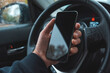 © Bits and Splits - Car driver holding mobile smart phone over steering wheel, blank black screen