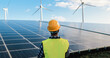 Engineer working for alternative green energy farm - Wind turbine and solar panels - Focus on helmet