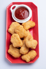 Wall Mural - Chicken nuggets with tomato sauce in red plate