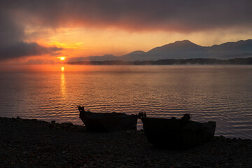 Wall Mural - Fishing boat on the shore of the lake Liptovska Mara, Slovakia. Colorful sunrise on the sky