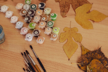 Yellow and brown Dried leaves, a set of acrylic paints and brush