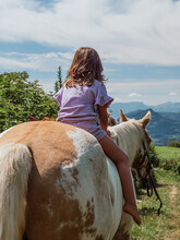 Girl Riding Horse In Hilly Terrain