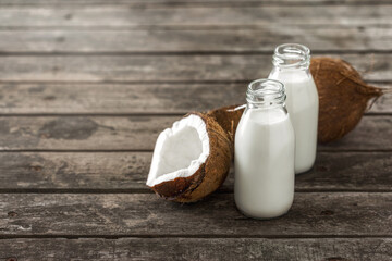 Wall Mural - Coconut milk in bottles on wooden table with copy space.  Healthy eating concept