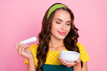 Poster - Photo of cute shiny young woman wear green apron enjoying aroma preparing herbs smiling isolated pink color background