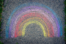 The Rainbow Is Drawn With Chalk On The Asphalt. Colored Rainbow On The Sidewalk