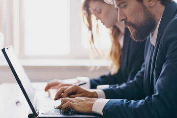 Wall Mural - business man and woman sitting at a desk with a laptop communication finance technologies