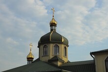 Church With Two Yellow Domes With Crosses On Green Roofs Against A Gray Sky