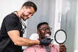 © hedgehog94 - African American man having dental treatment at dentist's office.