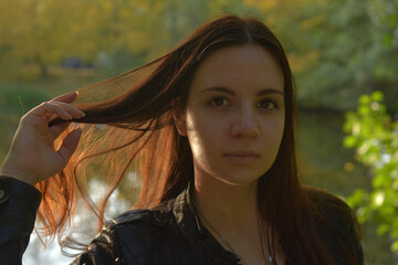 girl in a black leather jacket and black jeans in an autumn park