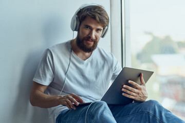 Wall Mural - bearded man sitting on the windowsill relaxation