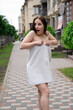 © OliaVesna - confident brunette woman in white towel running by the street. crazy beautiful millennial carefree girl.