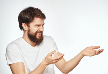 Canvas Print - Cheerful man with a beard in a white T-shirt gestures with his hands