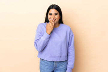 Wall Mural - Young latin woman woman over isolated background happy and smiling covering mouth with hand