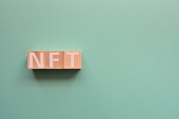 Poster - The cubes arranged in the word NFT It's an abbreviation for Non-Fungible Token. Copy space available.