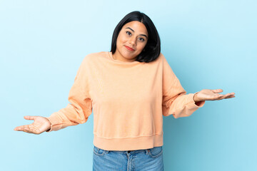 Wall Mural - Young latin woman woman isolated on blue background happy and smiling