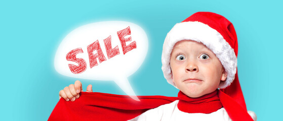 A little surprised boy in a Santa hat announces of sales 