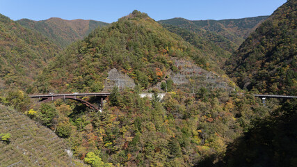 Wall Mural - A road that can be seen in the distance in the autumn mountains