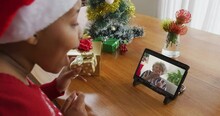 African American Woman With Santa Hat Using Tablet For Christmas Video Call, With Woman On Screen