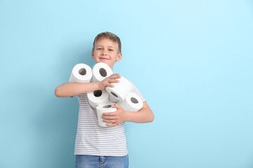 Wall Mural - Cute little boy with many rolls of toilet paper on blue background