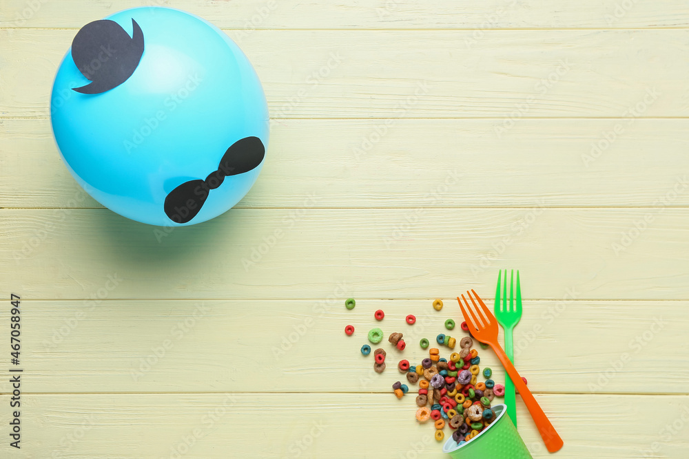Creative balloon and cereal rings on color wooden background