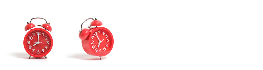 Two red alarm clocks on a white background.