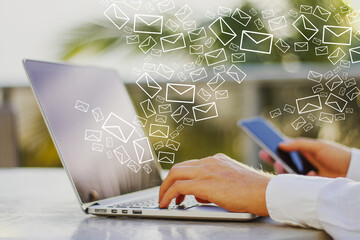 Aufkleber - Close up of male hands using smartphone and laptop at desktop with creative drawn email icons on blurry outdoor background. Business, technology, communication and e-mail marketing concept.