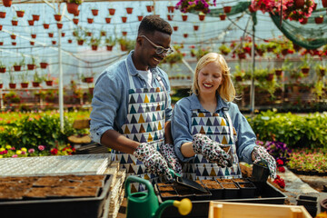 Diverse garden workers in greenhouse