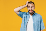 Fototapeta  - Young puzzled embarrassed bewildered caucasian man 20s wearing blue shirt white t-shirt scratch head look aside say oops isolated on plain yellow background studio portrait. People lifestyle concept.