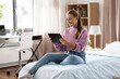 © Syda Productions - children, technology and communication concept - smiling teenage girl with tablet computer sitting on bed at home