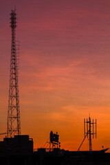 Canvas Print - Vertical shot of silhouettes of transmission towers at sunset