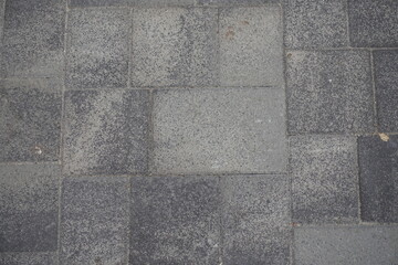 Wall Mural - Top view of pavement made of rectangular gray concrete blocks