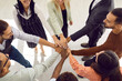 © Studio Romantic - Smiling diverse business team stacking hands. Mixed race group of happy young people putting hands together, high angle shot, top view, from above, close up. Teamwork, motivation and support concept