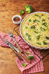 Wall Mural - Homemade quiche with red fish, salmon, broccoli and cheese on wooden background