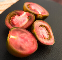 black halves of tomatoes on black stone board