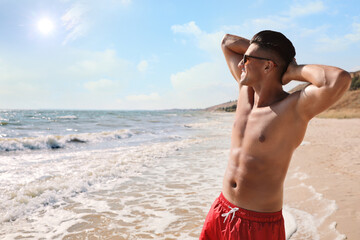 Poster - Handsome man with attractive body on beach. Space for text