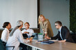 © Drobot Dean - Multiracial men and women discussing project during meeting in office