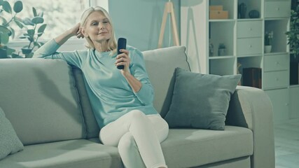 Poster - Cheerful relaxed dreamy lady sit comfortable couch hold remote control watch tv