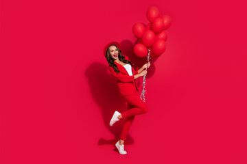 Sticker - Photo of charming excited young woman wear suit jacket cap smiling holding balloons isolated red color background