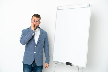 Young business woman giving a presentation on white board isolated on white background with surprise and shocked facial expression