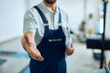 © Drazen - Close-up of auto mechanic offers handshake at his workshop.
