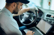© Drazen - Auto mechanic runs diagnostic on laptop while sitting inside of car at workshop.
