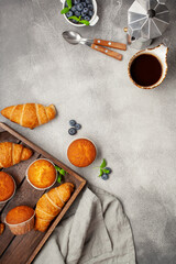 Wall Mural - Continental breakfast captured from above (top view, flat lay). Coffee,  juice, croissants,muffins and blueberry.