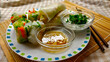 Delicious Vietnamese spring rolls full of fresh vegetable and glass noodles with typical vinegar sauce and less typical mayonnaise dressing with spring onion. Some of the spring rolls are cut half. Th