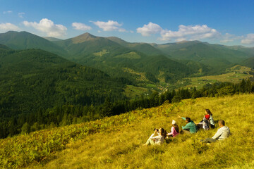 Sticker - Group of tourists sitting on hill in mountains