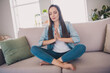 © deagreez - Portrait of attractive cheery dreamy religious long-haired woman sitting on divan staying safe praying at home indoors