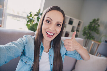 Sticker - Self-portrait of attractive cheerful long-haired woman showing thumbup advert staying at home indoors