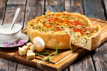 French opened pie quiche with chicken on a wood board