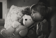 Grayscale Photo Of Girl Hugging Bear Plush Toy
