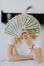 Woman Holding Fan Of US Dollar Bill Paper Money